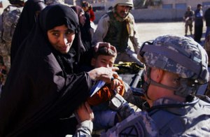 Capt. Damon Dudihy, C Company, 210th BSB, examines a young Iraqi boy at a medical operation in the Al-Jazir neighborhood of Mahmudiyah, Iraq, Dec. 25. The operation, orchestrated by A Company, 2nd Battalion, 15th FA Rgt., provided medical care to residents of Al-Jazir and neighboring village Al-Rakub. Photo by Spec. Chris McCann