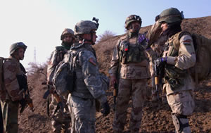Staff Sgt. Michael Myers (center), a military transition team trainer with 2nd Battalion, 15th Field Artillery Regiment, discusses the next move with Iraqi soldiers during a tactical halt. Photo by Spec. Chris McCann